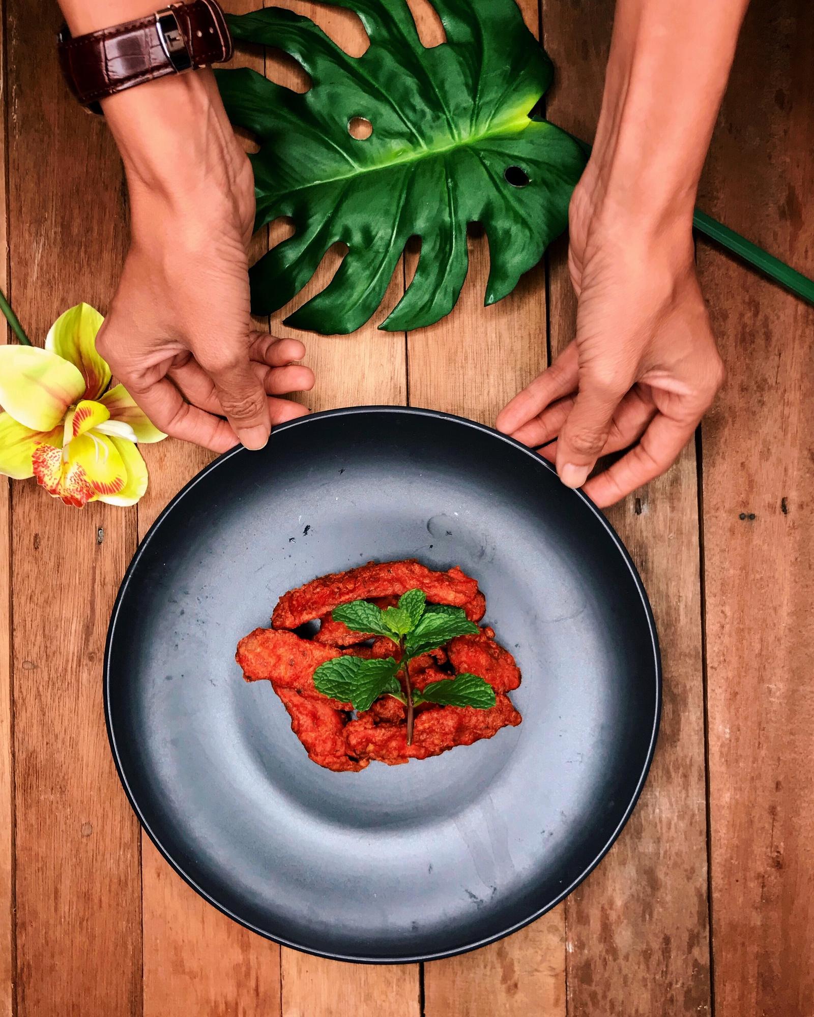 Chef arranging plated dish on wooden table